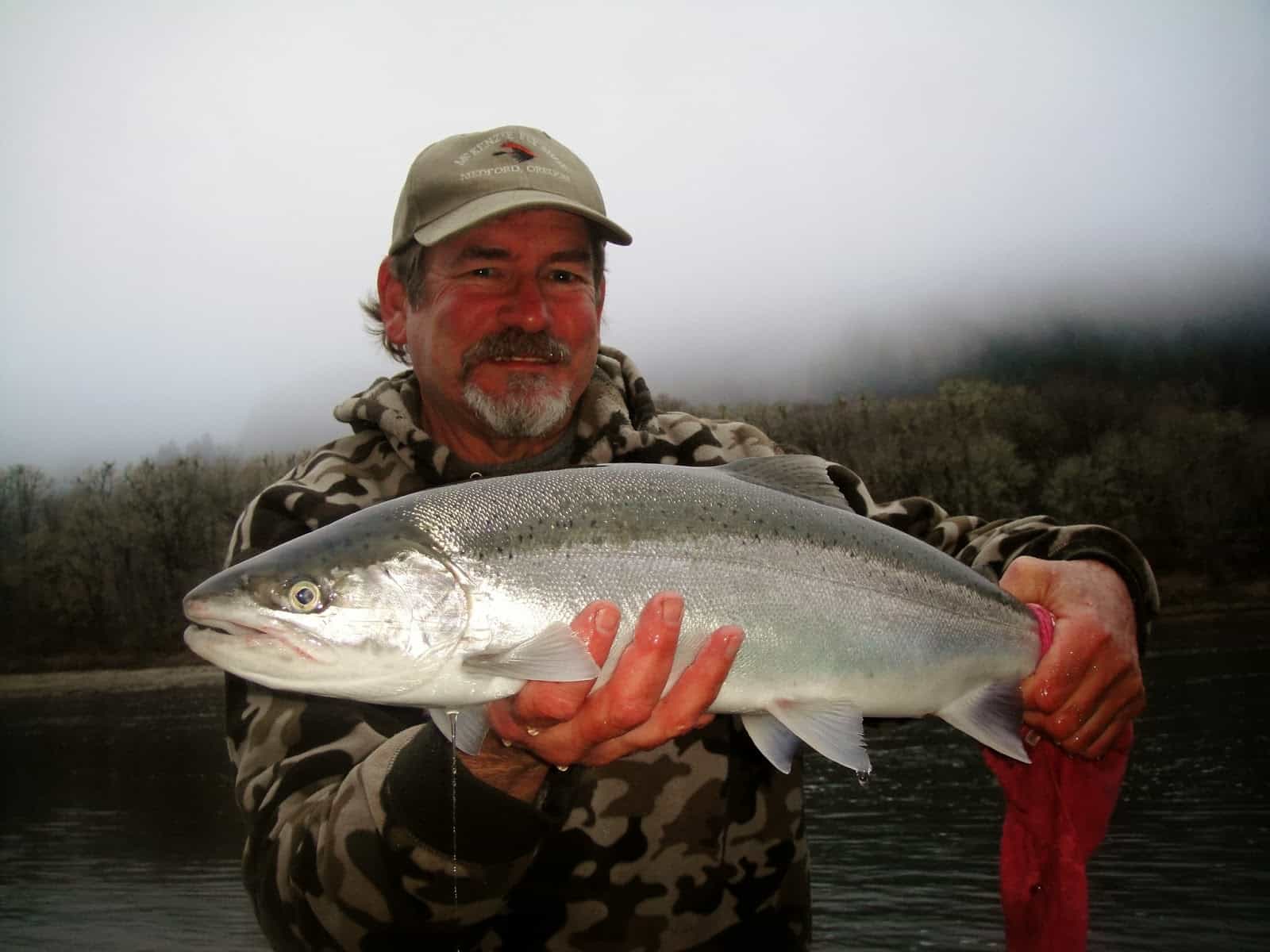 Chrome bright Umpqua winter steelhead held by Fred on a guided fishing trip.